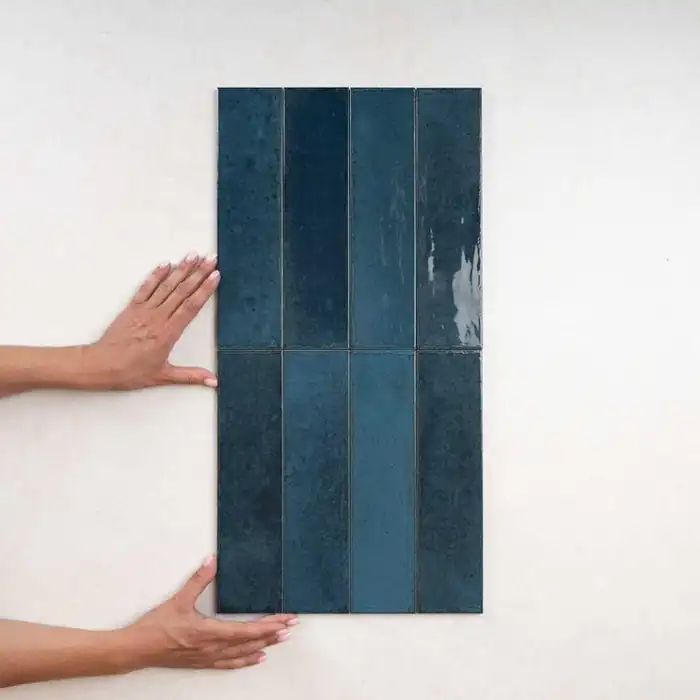 Le zellige dans la cuisine : le charme de l'imparfait 2 Pose de carreaux de zellige bleu sur un mur, mains en train d'ajuster les carreaux