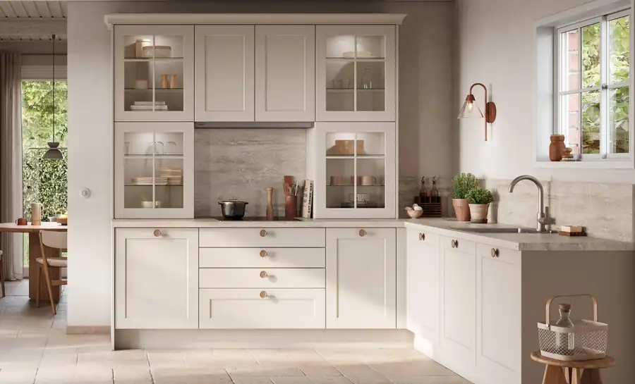 Façade de cuisine à cadre : le grand retour du style shaker 3 Cuisine campagne chic à façades shaker crème avec meubles vitrés et poignées en laiton